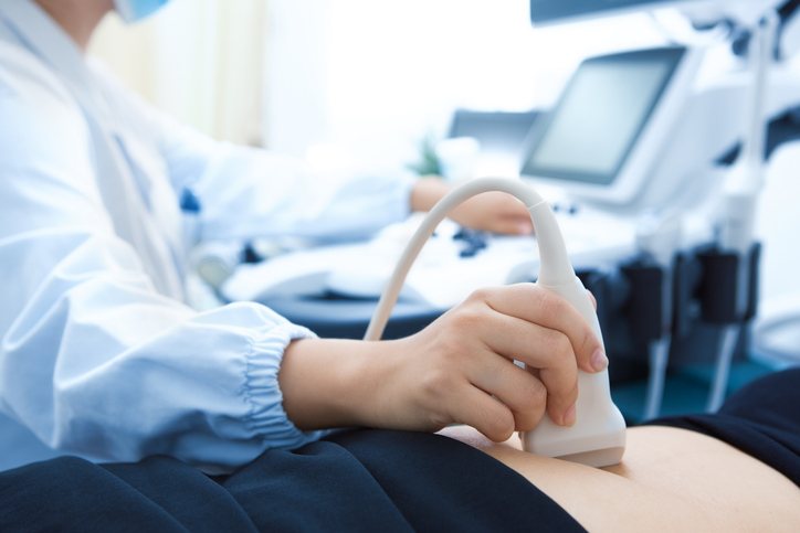 An abdominal ultrasound in progress, the probe on the patient's abdomen