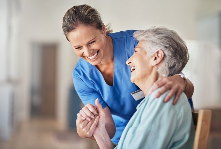 A smiling older patient with a caregiver